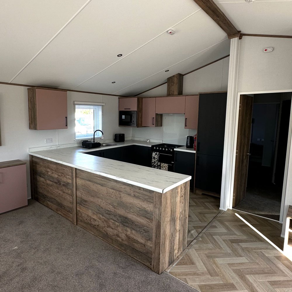 Lodge kitchen with pale cabinetry, oven and dining space