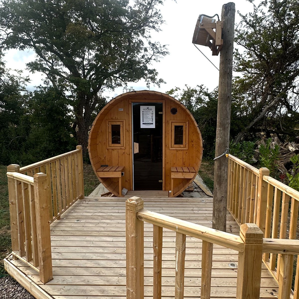 The timber walkway leading to the sauna, under the trees at the edge of the site